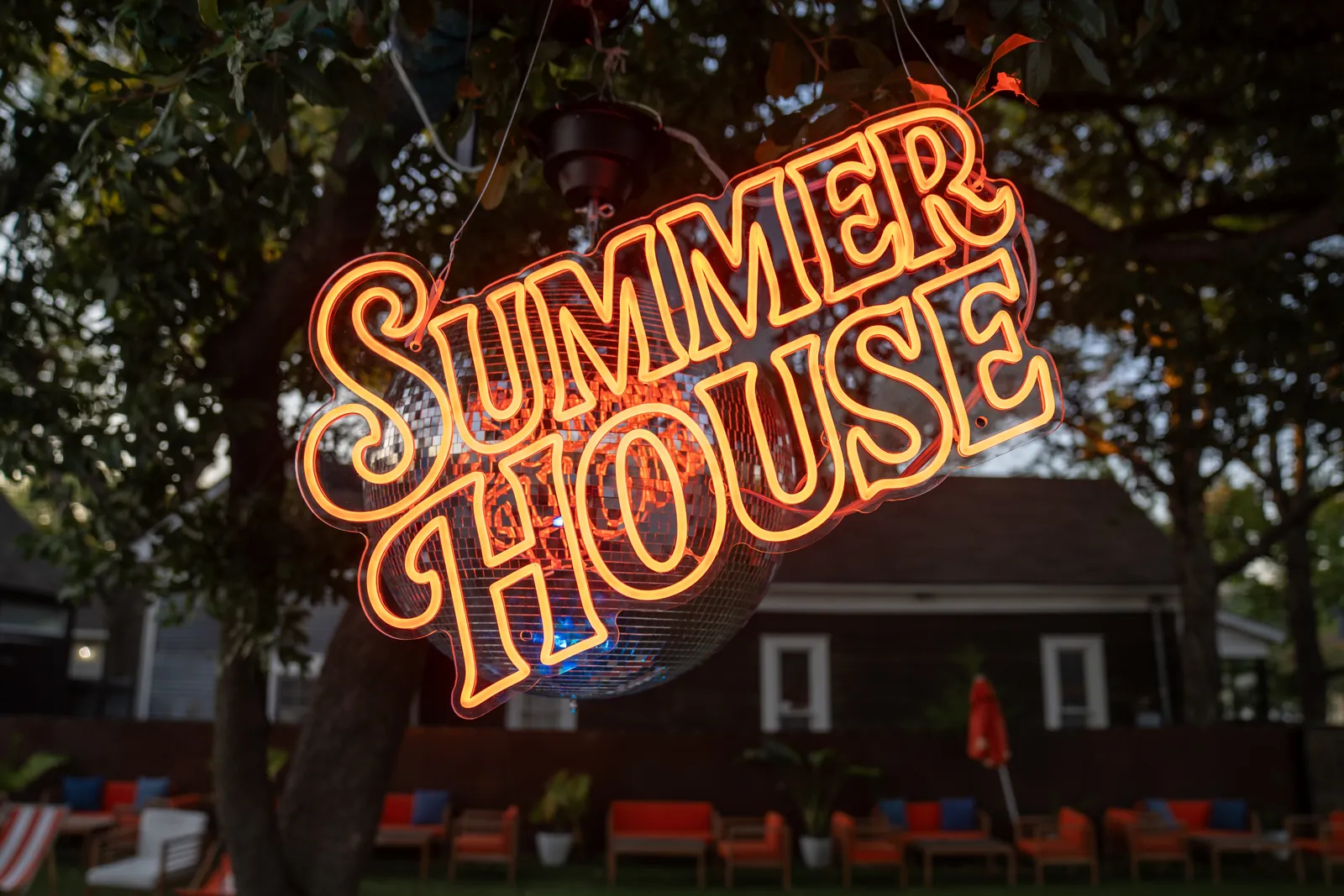 Summer House neon sign glowing poolside
